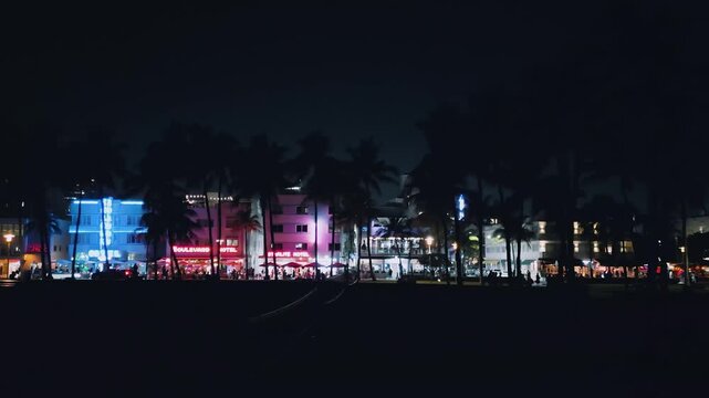 Glowing Collins Avenue stretches across Miami Beach in vivid aerial night footage