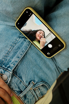 Smartphone with process of woman applying lipstick in the screen