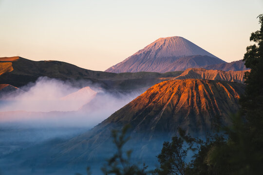 Sunrise Illuminating Mount Batok and Mount Semeru Volcano with Morning Mist in Bromo Tengger Semeru National Park East Java Indonesia