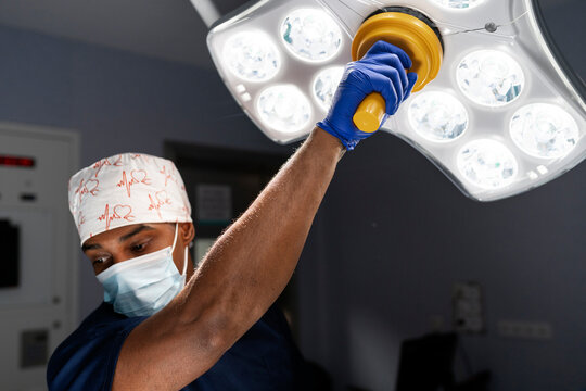 Surgeon adjusting surgical light in operating room