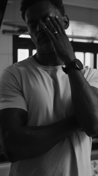 African American husband holding neck and looking away while wife talks in kitchen