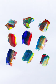 Strokes of multi-colored paint on the surface of paper