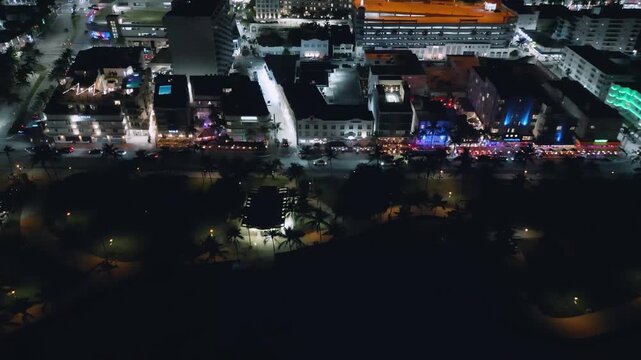 Collins Avenue gleams with electric cyan and orange lights in this flowing Miami Beach drone