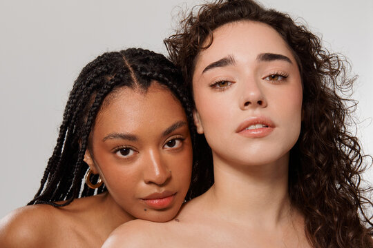 Two Women Posing Together in a Studio Setting With Neutral Background