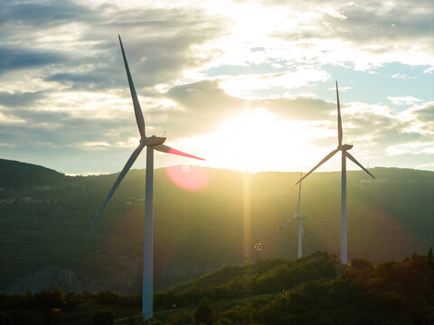 Aerial view of wind turbines on a hillside during golden hour in Affi, Veneto, Italy.