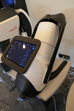 Examiner side with large touchscreen on modern italian  ophtalmology fundus imaging system iCare DRS Plus, with large touchscreen, displayed on medical expo. Visionix VX 120 in background. 