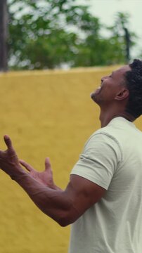 African American man looking upward with open hands in hopeful prayer and devotion