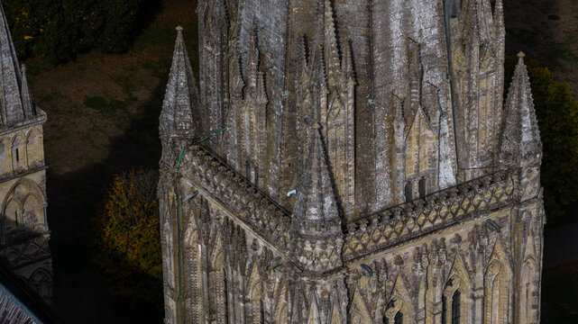 Aerial view of the intricate stone spire and gothic architecture of Salisbury Cathedral in Salisbury, England, United Kingdom.