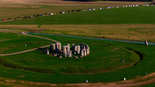 Aerial view of Stonehenge, a prehistoric monument of standing stones set within earthworks, surrounded by green fields and a road in Salisbury, England, United Kingdom.