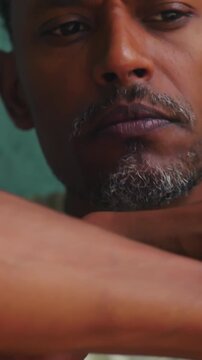 African American man with hands on head looking down in emotional stress and introspection