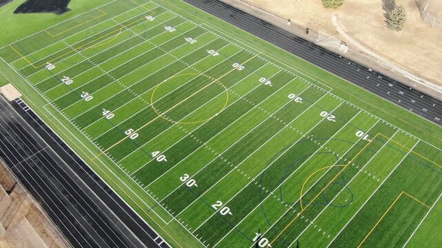 Aerial Drone View of a Green American Football Field and Running Track.