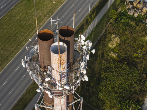 Aerial view of a telecommunication tower equipped with numerous antennas and relays, positioned beside a road in Krakow, Lesser Poland Voivode, Poland.