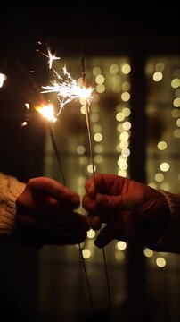Happy new year video. Hands Holding Sparklers near Window Concept of New Year Eve video, Festive Celebration, Christmas Cozy Winter Night, Holiday Moments