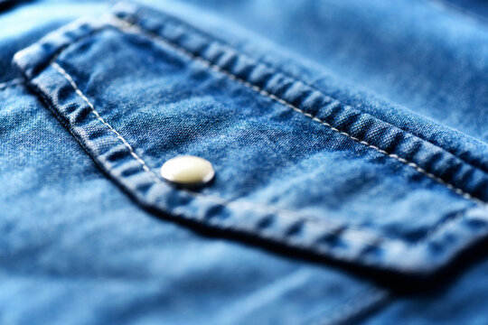 Close up of blue denim shirt with buttons. Soft focus.