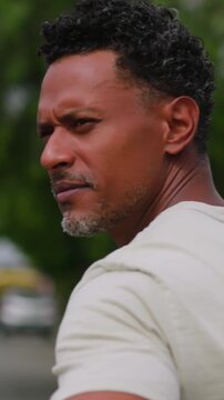 African American man stopping and turning around on urban street with pensive expression