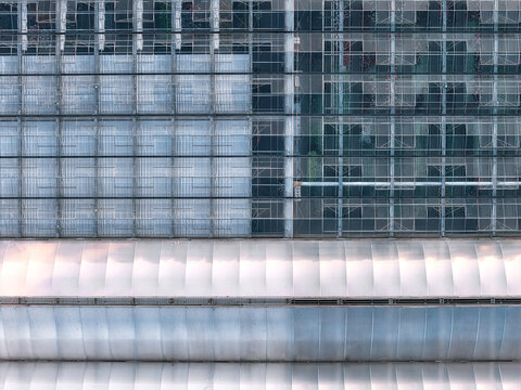 Aerial view of a large industrial greenhouse complex with glass panels and curved roof sections in Beckum, North Rhine-Westphalia, Germany.