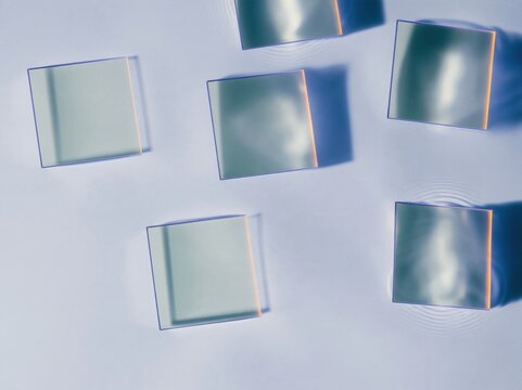 Translucent mint squares with purple rims floating on calm water, a clean and minimal abstract composition for streaming and subscription themes