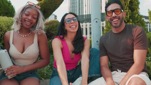 Group of multiracial friends gesturing and laughing outdoors