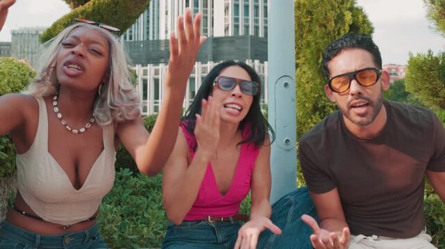 Diverse group of friends dancing and singing in an urban park