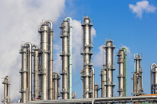 Pipes, pipelines and cooling towers at an industrial oil refinery and power station as part of the energy production infrastructure.