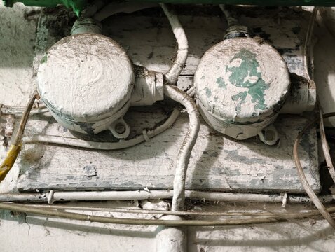 Old electrical wires on a wall, suitable for use as a background or in a scene about aged infrastructure