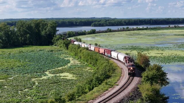Train locomotive pulling a freight train along the back waters of the Mississippi river.