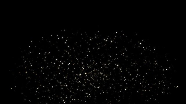 A close-up shot of golden glitter particles expanding outwards from the center before shrinking back against a solid black background.