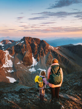 Parent and kid mountaineering in Norway during autumn holidays, family mother and child mountain hiking outdoor adventure active tourism bonding exploration and recreation in Lyngen Alps