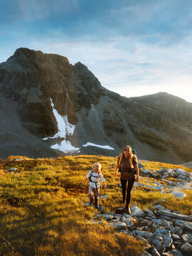 Mom and daughter hiking together in Norway climbing mountains together, family travel vacations explore Lyngen Alps trails outdoors adventure healthy lifestyle active holidays parent mother and kid