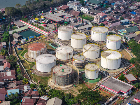 Aerial view of the PT. Pertamina TBBM Samarinda fuel storage facility with large white cylindrical tanks surrounded by urban infrastructure in Samarinda, East Kalimantan, Indonesia.