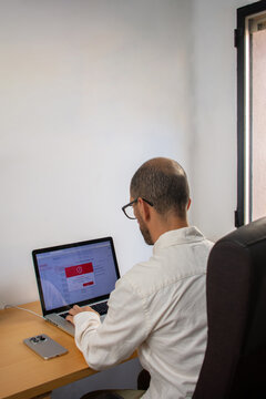 Man staring at laptop with email security warning