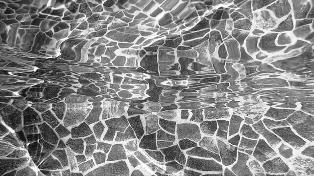 Pure beige water with reflections sunlight in slow motion. Water surface texture top view. Sun and shadows. Motion clean swimming pool ripples and wave.