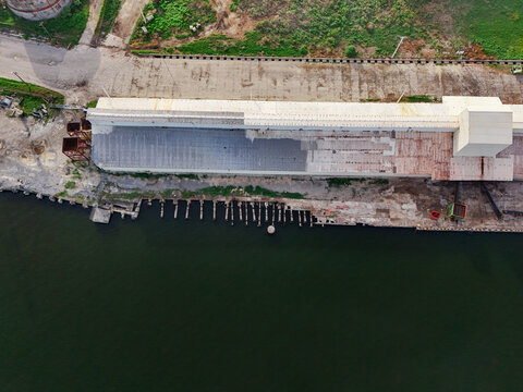 Aerial view of an industrial warehouse building situated along the banks of the Rio Higuamo in San Pedro de Macoris, San Pedro de Macoris, Dominican Republic.