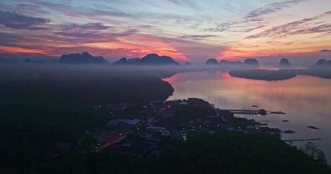 Aerial view of scenery sky reflection at Ban Sam Chong fishing village at twilight. Reflection of the dusk sky in a fishing village living, isolated island surrounded by mangrove forests.