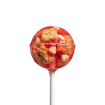 A round lollipop with a transparent hard candy shell filled with cookie chunks and white chocolate chips on a white stick, isolated