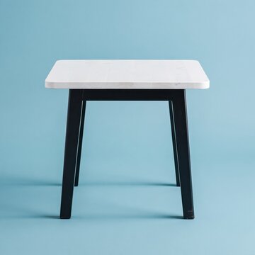 Wooden table with a white planked top and black tapered legs on a bright blue background, for furniture ecommerce and product listings