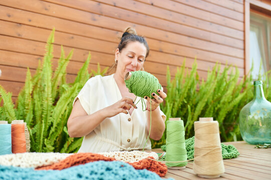 Female artisan enjoying crocheting hobby outdoors