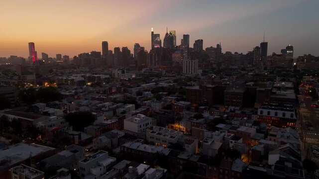4k 59 Aerial footage between buildings and structures, with a sunny sunset in the background and traffic moving along streets and avenue.