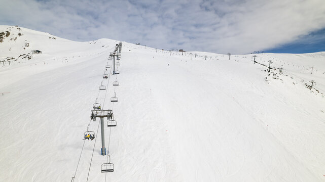 Aerial view of the chairlift ascending the snow-covered slopes of Cerro Catedral with skiers visible on the lift in Bariloche Department, Rio Negro Province, Argentina.