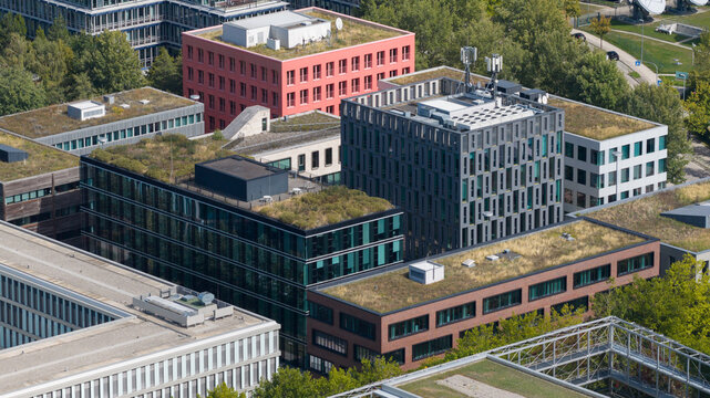 Aerial view of the modern campus buildings with green roofs, solar panels, and landscaped courtyards in Unterfohring, Bayern, Germany.