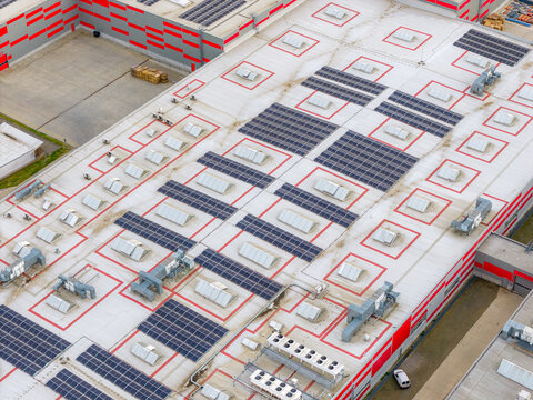 Aerial view of an industrial building roof featuring extensive solar panel arrays, numerous skylights, and HVAC units in Breclav, South Moravian Region, Czechia.