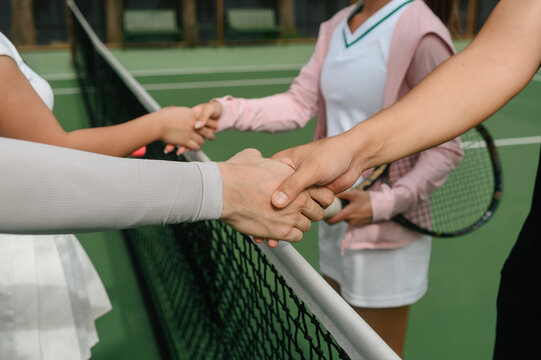 Close up of a Four Tennis Players Shaking Hands Over the Net After Match on Outdoor Court