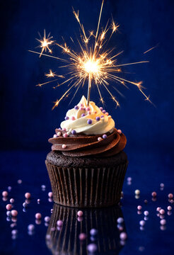 Chocolate cupcake with vanilla frosting and sparkler on top