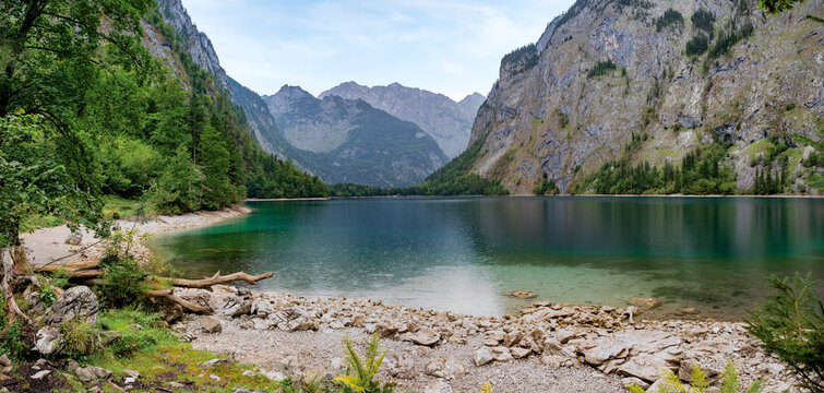 Konigssee lake shore with steep mountain slopes and deep green forests in Bavaria Germany