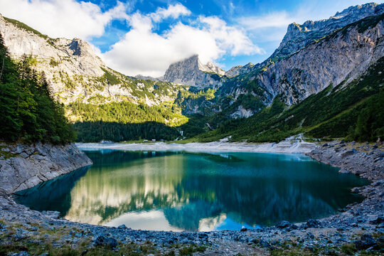 Serene Alpine Lake Hinterer Gosausee Reflects Majestic Mountains and Cloudy Sky in Upper Austria