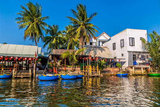 A view of a traditional basket boat dock along the waterways of the Bay Mau Coconut Forest in Cam Thanh village near Hoi An, Vietnam on a bright sunny day