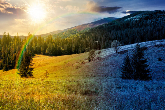 rural fields on autumn equinox. day meet night. sun and moon over trees on the grassy hills at twilight. beautiful countryside scenery of carpathian mountains. clouds on the epic sky