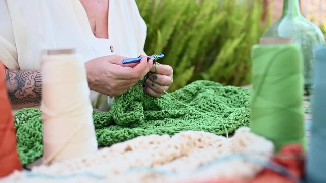 Woman crocheting green yarn with crochet hook,  video 4k real time
