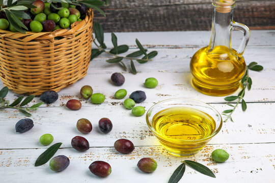 fresh olives and olive oil on wooden background