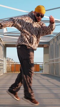 Full length shot of young stylish guy dancing hip hop outdoors in sunlight youth freedom energy and street culture concept vertical slow motion video stock